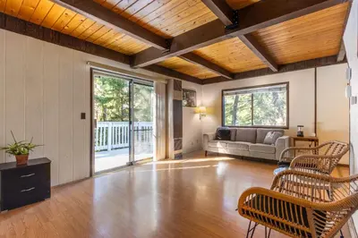 a living room with a couch and a table at Cozy 2BR Retreat Near Lake Grego with Mountain Views in Crestline
