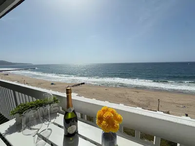 a bottle of wine sitting on a balcony overlooking the beach at Oceanfront 1 Bed 1 Bath , Parking, Stunning View 337 in Redondo Beach