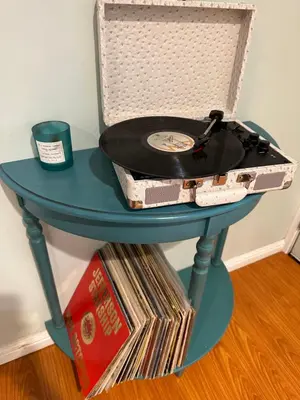 a turquoise table with a record player and records at Suburban oasis home in Monterey Park