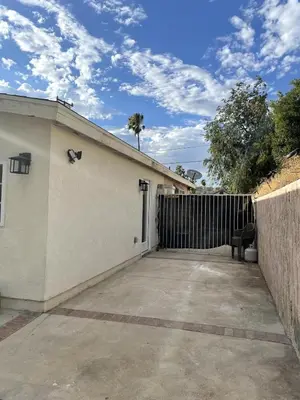 a white building with a gate and a fence at Modern 1-bedroom Studio with Kitchen and Laundry in Santa Clarita