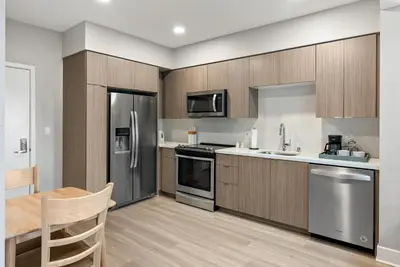 a kitchen with stainless steel appliances and wooden cabinets at Spacious Loft- Hollywood Free Pool, Parking, Gym in Los Angeles