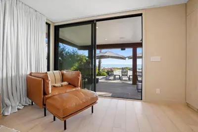 a living room with a leather chair and sliding glass doors at The Surf Lodge Villa in Malibu