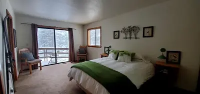 a bedroom with a bed and a balcony at Blue Jay's Nest Sequoia Cabin in Ponderosa, CA in Ponderosa