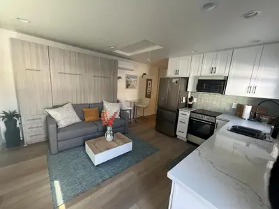 a living room with a couch and a kitchen at Private guest cottage in Long Beach
