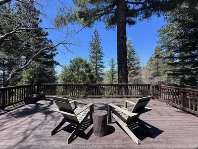 two chairs and a table on a wooden deck at A-Frame with Carousel Fireplace in Running Springs