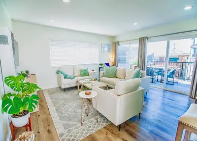 a living room with a couch and a table at Beach House Steps to the Sand! in Manhattan Beach