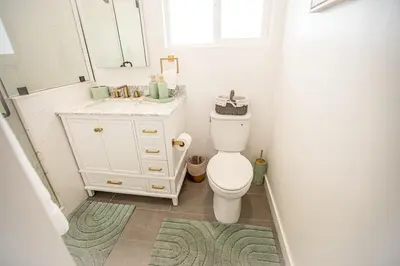 a bathroom with a white toilet and a sink at Beach House Steps to the Sand! in Manhattan Beach