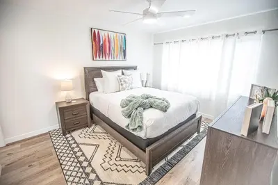 a bedroom with a bed and a dresser and a window at Beach House Steps to the Sand! in Manhattan Beach
