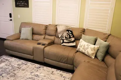 a brown leather couch in a living room with pillows at Pretty Relaxed Me in Brea