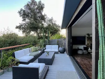 a patio with a couch and a table and a tv at Tranquil and Secluded Retreat in Topanga Canyon in Topanga
