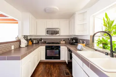 a kitchen with white cabinets and a sink at Tranquil and Secluded Retreat in Topanga Canyon in Topanga