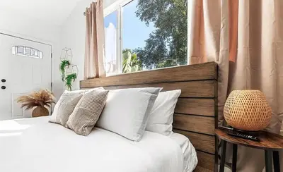 a bedroom with a bed with white pillows and a window at Love & LuxuryHeart Shaped Pool Paradise in Los Angeles