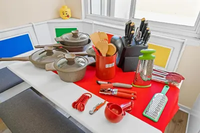 a table with kitchen utensils on a red blanket at Princess Palace by OC Adventure Homes in Anaheim