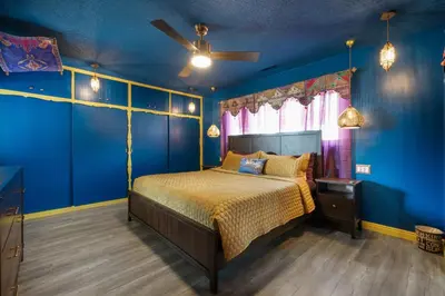 a bedroom with a bed with blue walls and a ceiling at Princess Palace by OC Adventure Homes in Anaheim