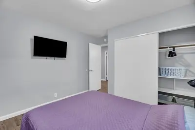 a bedroom with a purple bed and a flat screen tv at Sunny Simi Valley Valley 4BR 3BR LTR Modern Home Dedicated Work Place High Speed internet in Simi Valley