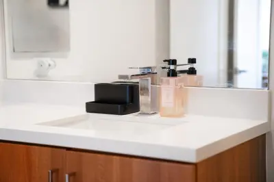 a bathroom counter with a sink with products on it at Heart of North Hollywood 2 bed Apt FREE parking, hot tub, pool, gym in Garnsey