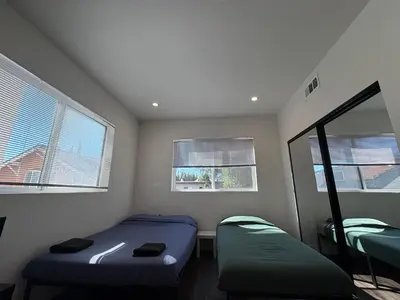 two beds in a room with two windows at Blue Central Stay Near USC, BMO Stadium & Downtown LA in Los Angeles
