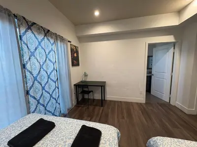 a room with a bed and a table and a window at Blue Central Stay Near USC, BMO Stadium & Downtown LA in Los Angeles
