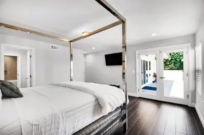 a white bedroom with a bed and a window at House in the Hills in Los Angeles