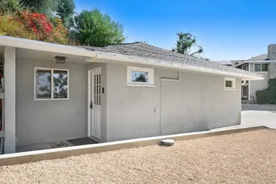 a gray house with a door in a driveway at Peaceful 5-Acre Stay - The Emerald Grove Retreat in La Verne