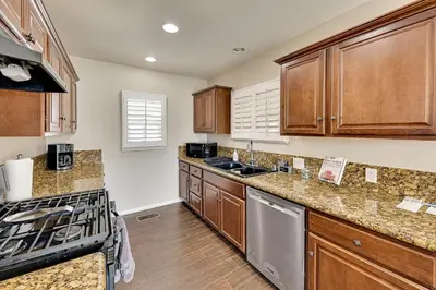 a kitchen with wooden cabinets and a stove top oven at 4 Mi to Dtwn Riverside Gem with Pool and Game Room in Riverside