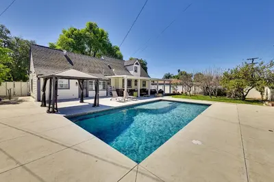 a swimming pool in front of a house at 4 Mi to Dtwn Riverside Gem with Pool and Game Room in Riverside