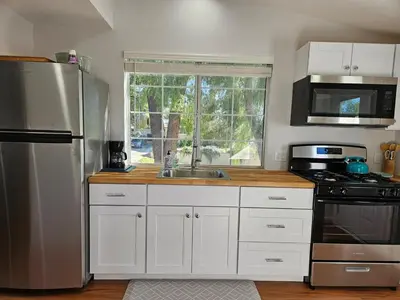 a kitchen with white cabinets and a stainless steel refrigerator at Modern 1-bedroom Studio with Full Kitchen and Bath in Santa Clarita