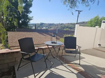 two chairs and a table with a lantern on a patio at Modern 1-bedroom Studio with Full Kitchen and Bath in Santa Clarita