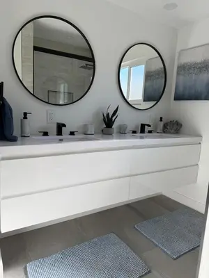 a white bathroom with two sinks and two mirrors at House with pool in prime location - 10 mins to Universal Studio in Garnsey