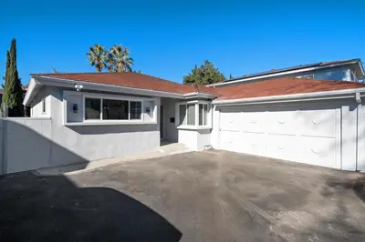 a house with a white garage and a driveway at House with pool in prime location - 10 mins to Universal Studio in Garnsey