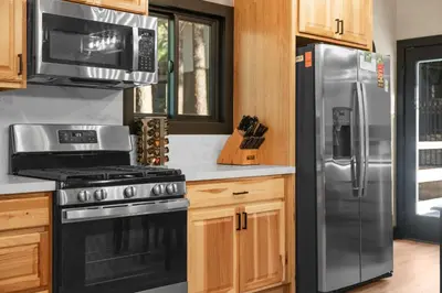 a kitchen with a stove and a refrigerator at Timber Wolf Tavern - Walk to Slopes, Game Room, Pool Table, BBQ in Big Bear Lake