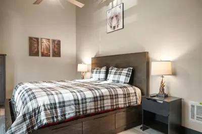 a bedroom with a bed and a dresser with two lamps at Timber Wolf Tavern - Walk to Slopes, Game Room, Pool Table, BBQ in Big Bear Lake