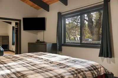 a bedroom with a bed and a window at Timber Wolf Tavern - Walk to Slopes, Game Room, Pool Table, BBQ in Big Bear Lake