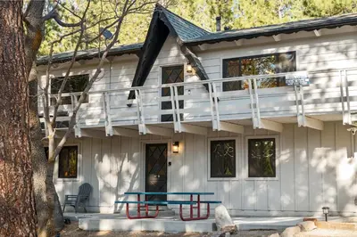 a house with a picnic table in front of it at Timber Wolf Tavern - Walk to Slopes, Game Room, Pool Table, BBQ in Big Bear Lake
