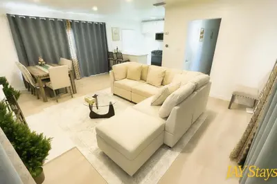 a living room with a white couch and a table at Newly renovated, warm home with 4 bedrooms, 14 miles from Disney in Whittier