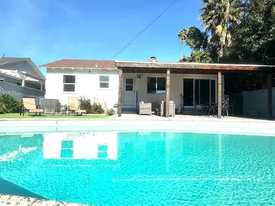 a swimming pool in front of a house at Cozy 3BR Home With Pool, Yard, Garage, and 80 inch TV! in Van Nuys