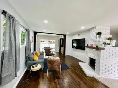 a living room with a blue couch and a fireplace at Cozy 3BR Home With Pool, Yard, Garage, and 80 inch TV! in Van Nuys