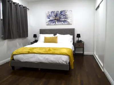 a bedroom with a bed with a yellow blanket on it at Cozy 3BR Home With Pool, Yard, Garage, and 80 inch TV! in Van Nuys