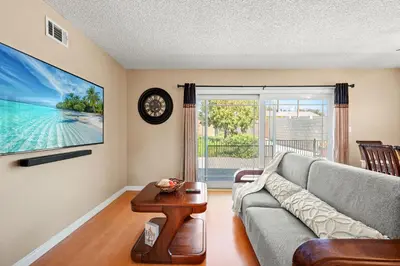 a living room with a couch and a clock on a wall at Modern 4B Retreat with Cozy Decor in Upland