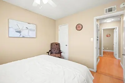 a bedroom with a white bed and a chair at Modern 4B Retreat with Cozy Decor in Upland