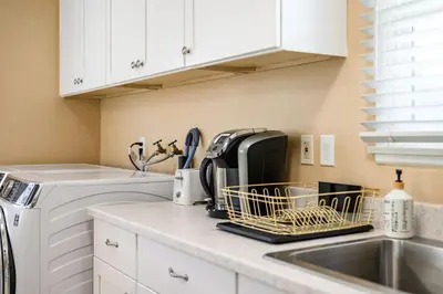 a kitchen with a sink and a dish drying rack at Modern 4B Retreat with Cozy Decor in Upland