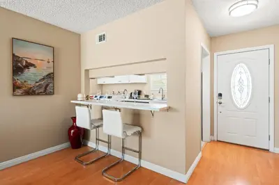 a kitchen with a sink and a counter with stools at Modern 4B Retreat with Cozy Decor in Upland