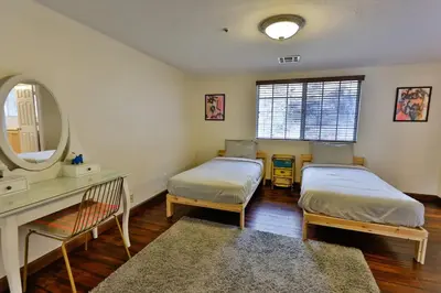 a bedroom with two beds and a vanity and a mirror at Amazing Escape near LA Meditation Room, Game room, Hot Tub, Pool in Leona Valley