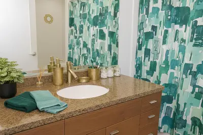 a bathroom with a sink and a shower curtain at Ocean Breeze Marina Suites with Pool, Gym & Hot Tub in Los Angeles