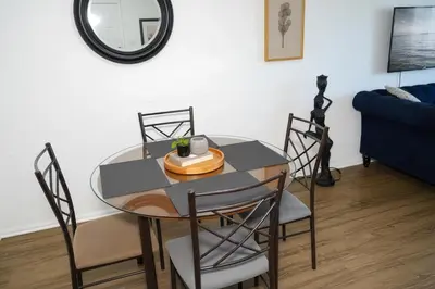 a dining room table with chairs and a mirror at Ocean Breeze Marina Suites with Pool, Gym & Hot Tub in Los Angeles
