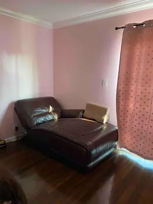 a black leather couch in a room with pink walls at Pool Front Romantic Getaway withPrivate Entry in North Hills