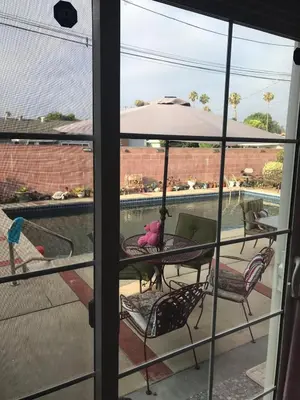 a patio with a table and chairs and an umbrella at Pool Front Romantic Getaway withPrivate Entry in North Hills
