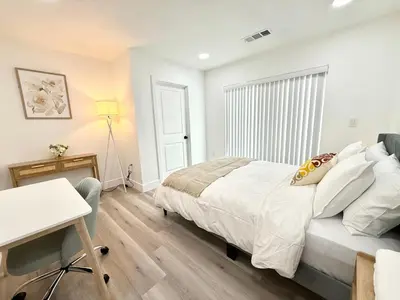 a bedroom with a bed and a desk and a window at GilmoreOne in Van Nuys