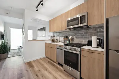 a kitchen with stainless steel appliances and wooden cabinets at Hollywood 1bdr apt with Pool, Free Parking, Gym in Los Angeles