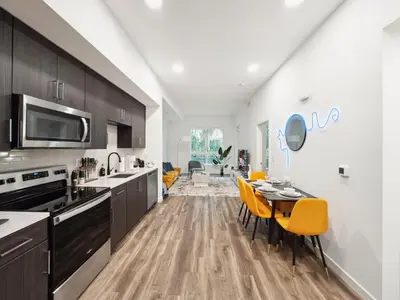 a kitchen with wooden cabinets and a table with yellow chairs at Spacious 1BDR near Walk of Fame with Luxury Amenities in Los Angeles